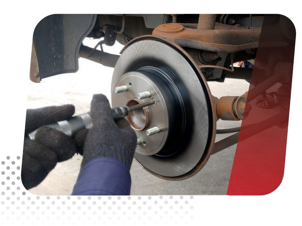 mechanic works on a car brake