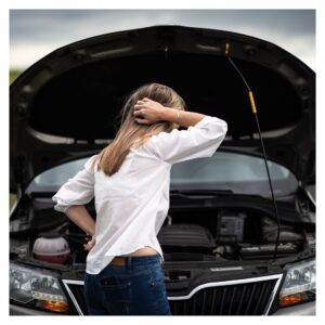 woman looking at car engine with her hand on her head