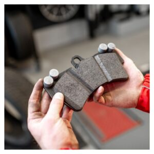 Technician examining thickness of brake pad